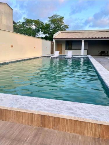 a swimming pool with chairs in the water at Ap Remanso - Cond Lençois Confort Barreirinhas in Barreirinhas
