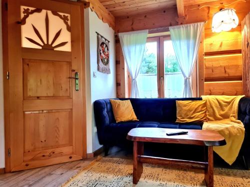 a living room with a blue couch and a window at Chata w Rabce - Bajkowa Osada in Rabka