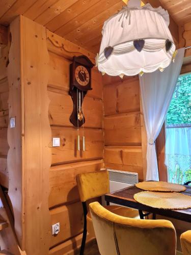 a dining room with a table and a clock at Chata w Rabce - Bajkowa Osada in Rabka