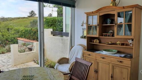 une cuisine avec une table et une porte coulissante en verre. dans l'établissement Garrigue sur cour, à Saint Pierre La Mer