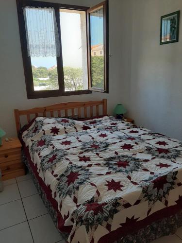 un lit avec une couette dessus dans une chambre dans l'établissement Garrigue sur cour, à Saint Pierre La Mer