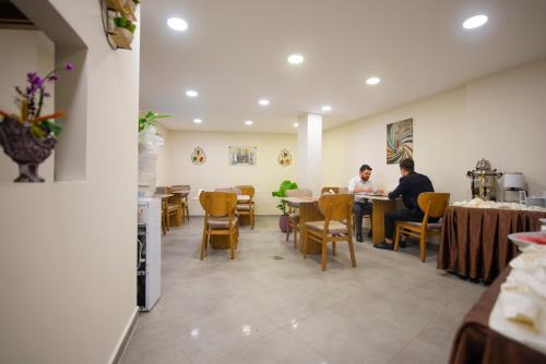 two people sitting at tables in a restaurant at Vera Life Hotel in Istanbul