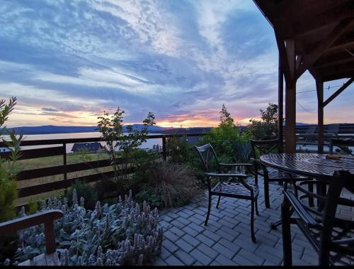 a patio with tables and chairs and a view of the water at Apartmán s terasou a výhledem na jezero Lipno in Kovářov