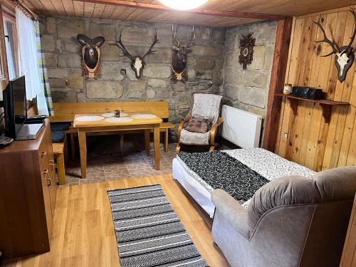 Zimmer mit einem Schlafzimmer mit einem Tisch und einem Sofa in der Unterkunft U myslivce in Chřibská
