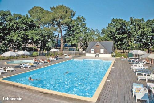 a swimming pool with chairs and people swimming in it at Les Marines du Treustel in Combrit