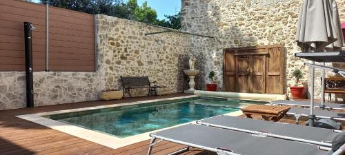 - une piscine au milieu d'un patio dans l'établissement LA ROSE DES VENTS, à Le Pouget