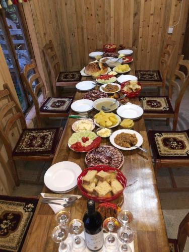 a long wooden table with plates of food on it at Katun Lanista-Kolibe Bogavac in Mojkovac