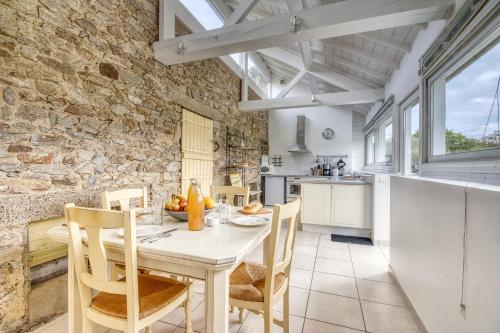 une cuisine et une salle à manger avec une table et des chaises dans l'établissement Le Gite Blanc, à Missillac