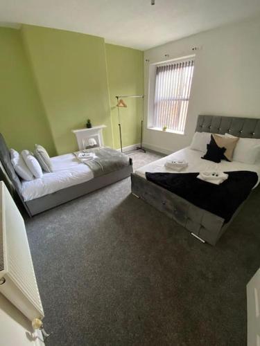 a bedroom with two beds and a television in it at Belle Vue in Pontnewynydd