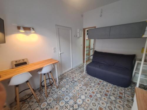 Habitación pequeña con cama, escritorio y taburetes en Studio 18 m2 à 100m de la mer, en Berck-sur-Mer