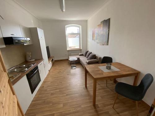 cocina y sala de estar con mesa y sofá en Ferienwohnung „Lochbach“, en Bad Mergentheim