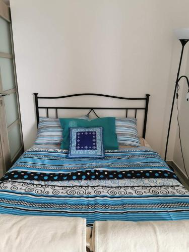 a bed with blue and white pillows on it at Apartmán s terasou a výhledem na jezero Lipno in Kovářov
