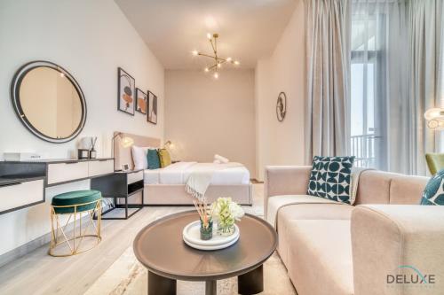 a living room with a couch and a table at Enchanting Studio at Mesk 1 Midtown Dubai Production City by Deluxe Holiday Homes in Dubai