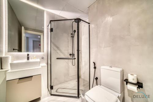 a bathroom with a shower and a toilet and a sink at Enchanting Studio at Mesk 1 Midtown Dubai Production City by Deluxe Holiday Homes in Dubai