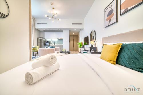 a bedroom with a large white bed with yellow pillows at Enchanting Studio at Mesk 1 Midtown Dubai Production City by Deluxe Holiday Homes in Dubai