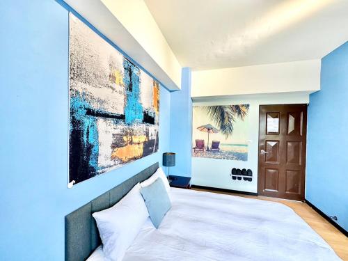 a bedroom with blue walls and a large painting on the wall at 莫蘭狄 in Taichung