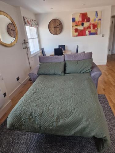 a bed with a green comforter in a bedroom at The Bank in Lewes