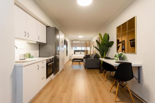 a kitchen and living room with a table and chairs at City Vibes Apartment in Thessaloniki