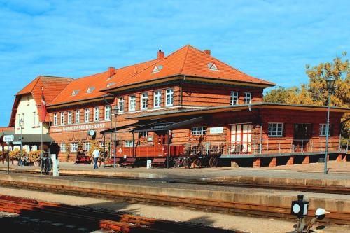 a train station with a large wooden building at Gemütliche Ferienwohnung Oase 22 in Kühlungsborn