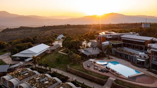 an aerial view of a resort with the sun setting over the mountains at Angels View Hotel in Graskop