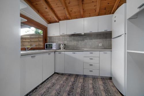 a kitchen with white cabinets and a sink at Amouage Boutique Home in Skiathos Town
