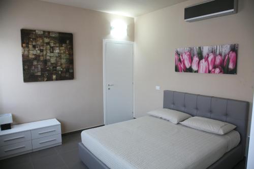 um quarto com uma cama e duas fotografias na parede em Siag Apartments em Cormano