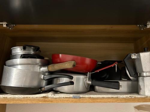 a pile of pots and pans sitting on a shelf at Dunas Apart Refugio Completo a 1Km Praia de St Antonio in Diogo