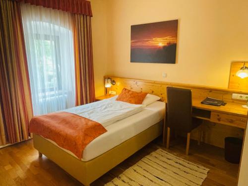 a hotel room with a bed and a desk and a computer at Hotel des Glücks - Landhotel Fischl in Sankt Oswald
