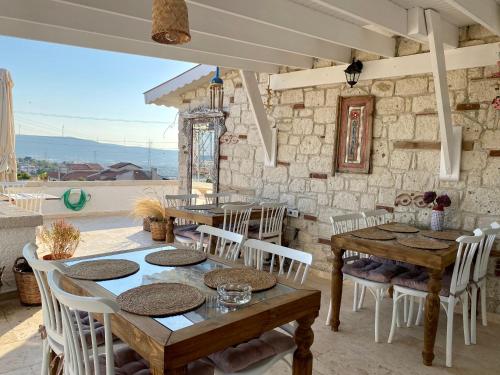 une salle à manger avec des tables en bois et des chaises blanches dans l'établissement Serez Otel Alaçatı by La Mira, à Ildır