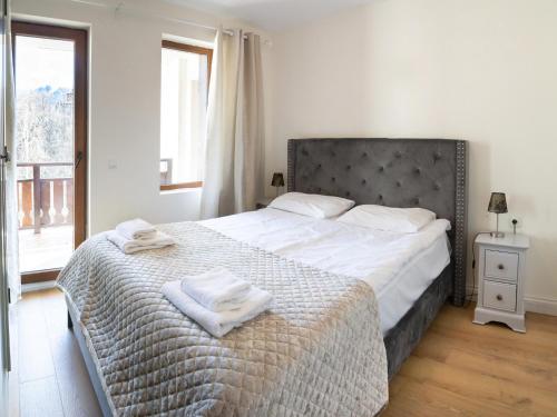 a bedroom with a large bed with towels on it at Predela 2 Aparthotel in Bansko