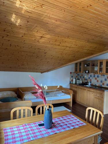 a room with a table with a vase on it at Apartments Zafran in Smoljanac