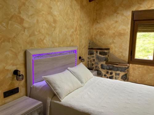 a bedroom with a white bed and a window at FUENTE OSCURA in Ramales de la Victoria