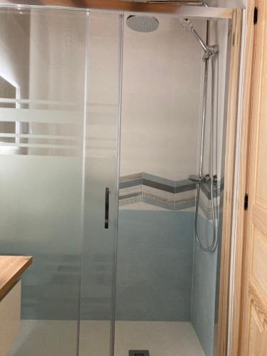 a shower with a glass door in a bathroom at FUENTE OSCURA in Ramales de la Victoria