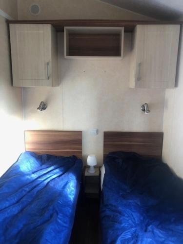 - une chambre avec 2 lits avec des draps bleus dans l'établissement mobilhome 582 Les Charmettes 3ch tout équipé, aux Mathes