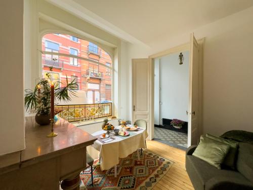 a living room with a table and a window at Ambiorix Residence in Brussels