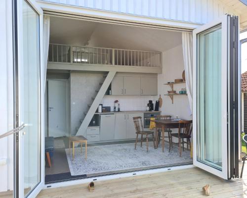 a kitchen with a sliding glass door open to a living room at Minihuset nära havet in Varberg
