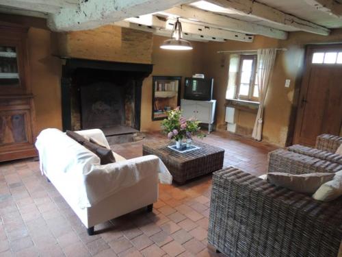 Elle comprend un salon doté d'un mobilier blanc et d'une cheminée. dans l'établissement Gites dans le parc classé du Martreil, à Sainte-Christine