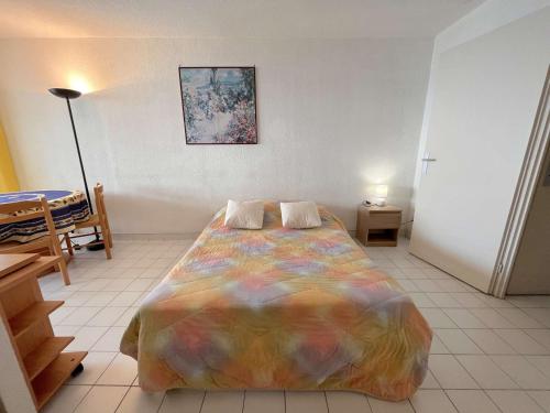 - une chambre avec un lit et une couverture colorée dans l'établissement Studio cabine pour 4 avec terrasse, près de Port Fréjus - FR-1-226A-249, à Fréjus