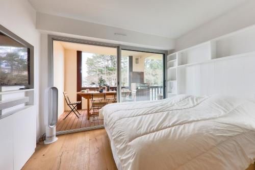 Un dormitorio con una cama y un balcón con una mesa. en Vue mer à Carnac, Duplex pour 8, en Carnac