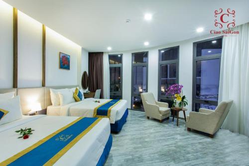 a hotel room with two beds and a sitting area at Ciao Saigon 2 Hotel in Ho Chi Minh City