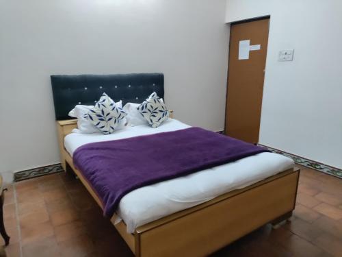 a bedroom with a bed with a purple blanket at Friendlystay - An Home Stay And Elite in Chennai