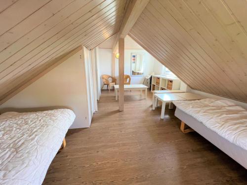 a attic room with two beds and a table at Strandpark Sierksdorf H091 in Sierksdorf