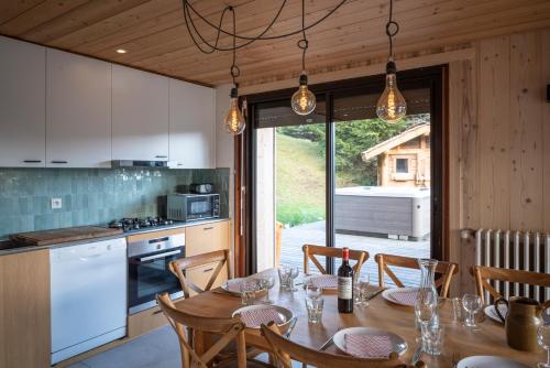 une cuisine et une salle à manger avec une table et des chaises dans l'établissement Chalet Les Carres, aux Gets