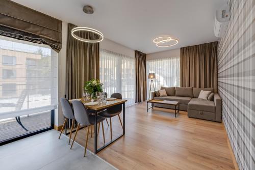 sala de estar con mesa, sillas y sofá en Apartamenty Pod Gondolą - Mountain Resort Villa z sauną - Dream Apart en Szczyrk