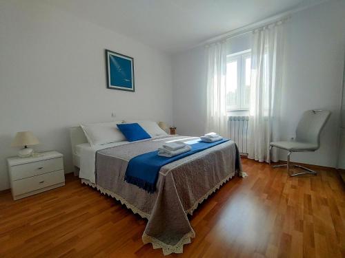 a bedroom with a bed and a chair and a window at Apartment Vetva in Nedeščina