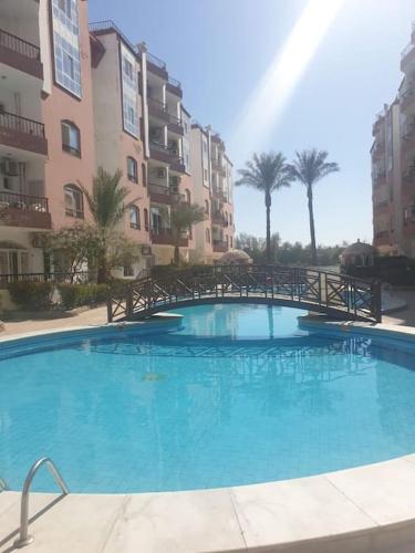 una gran piscina azul frente a un edificio en Sunny Studio - Desert Pearl Hurghada, en Hurghada