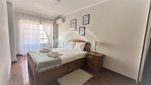 a small bedroom with a bed and a window at Varandas da Areia Branca in Praia da Areia Branca