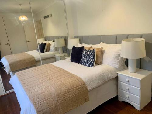 a bedroom with two beds and a large mirror at Location, Location, Location! Walk to beach & town in Mornington