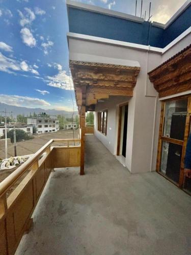 an empty balcony of a building with a blue roof at Hotel Bergo Residency - Leh in Leh