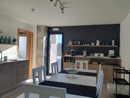 a kitchen and dining room with a table and chairs at Quinta de Cerdeiró in Mões
